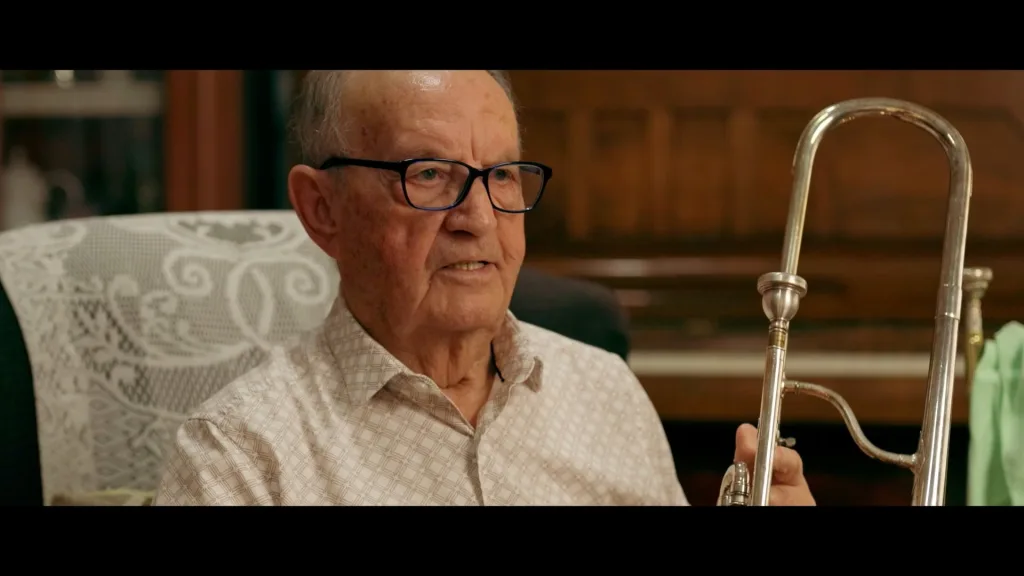 Older man seated with a trombone