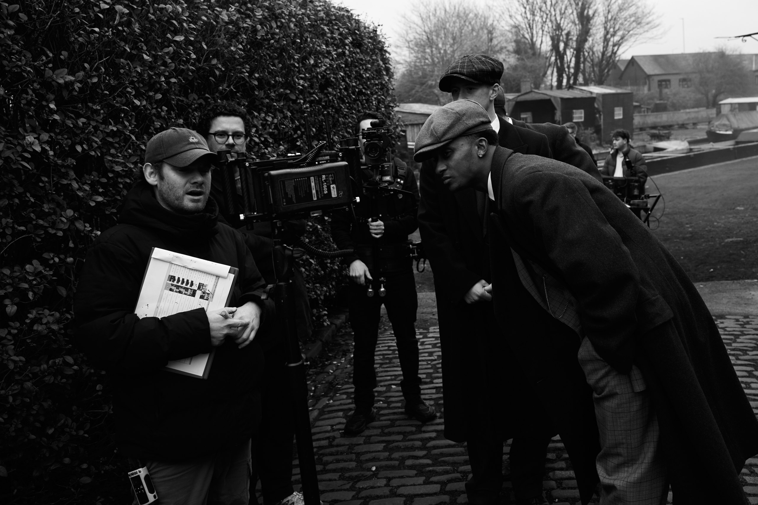 Sam St. John directing the cast of BCFC x Peaky Blinders on a cobbled street, storyboard in hand