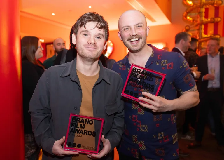 Sam St. John and a colleague holding their Brand Film Awards EMEA 2024 trophies